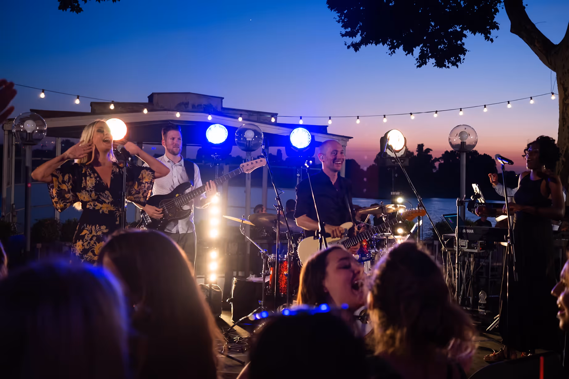Nahaufnahme der Live-Band beim Sonnenuntergangs-Event am See – filmisch eingefangen von Marcel Mader für emotionale Musikvideos.