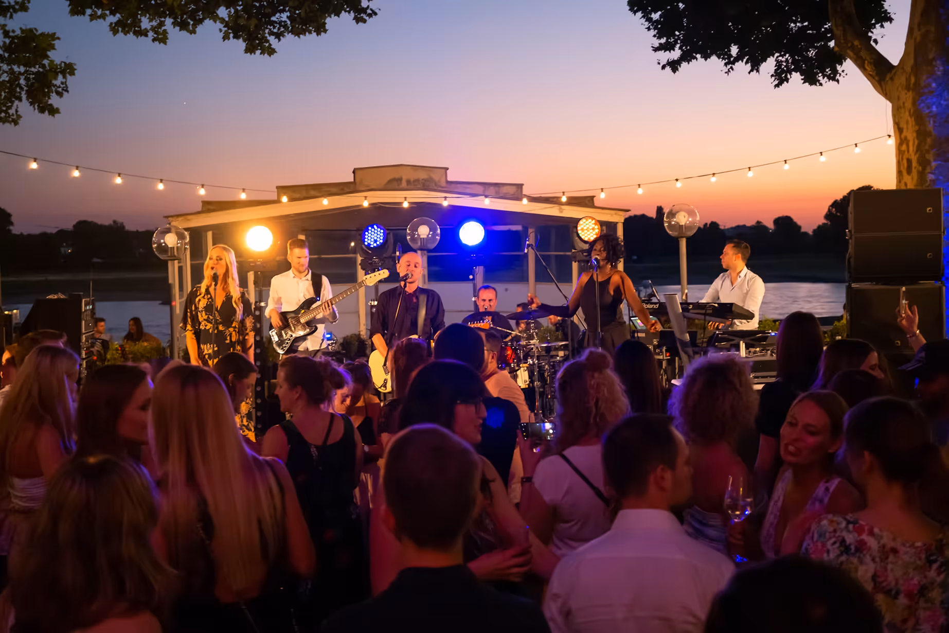 Open-Air-Konzert am See bei Sonnenuntergang mit Live-Band – inszeniert von Marcel Mader für hochwertige Event- und Festivalvideos.